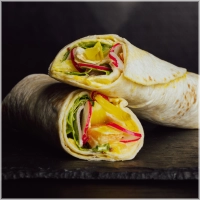 Deze wrap is gevuld met plantaardige kipfilet, vegan bacon, huisgemaakte piccalilly saus, radijs, Amsterdamse ui, kropsla en verse kiemgroenten. <br><i>Voor de echte vegan lover</i>!