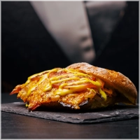 Huisgebraden beenham, langzaam gegaard met verse rozemarijn,knoflook, tijm, peper en zout. Daarbij gaat gesmolten cheddar, ijsbergsla en onze huisgemaakte honingmosterdsaus <br><i>Dit samen zorgt voor een heerlijke smaaksensatie</i>.