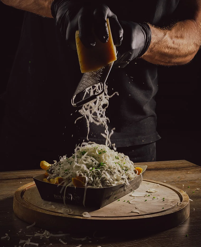 Bollino's Truffel Parmezaan: verse Parmigiano Reggiano wordt over knapperige friet met huisgemaakte truffelmayonaise en bieslook geraspt.